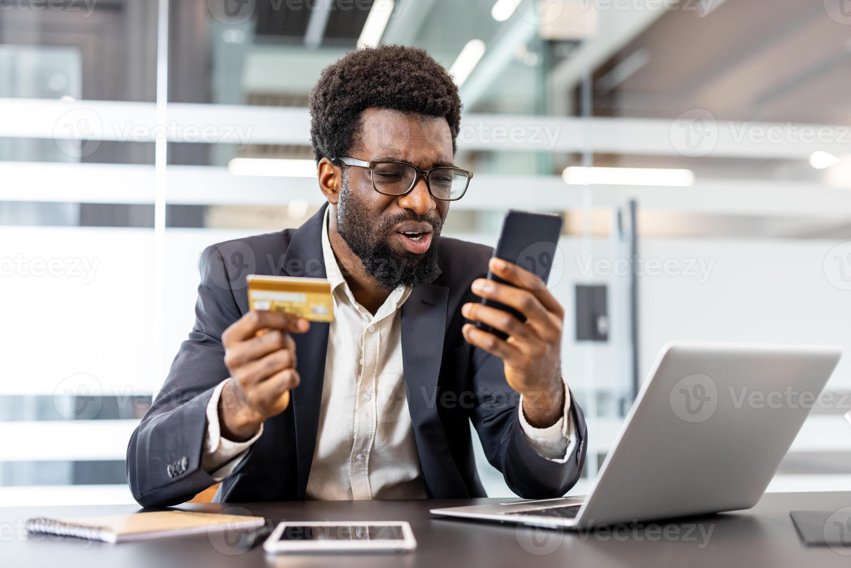 Adult man struggling with an online transaction, holding a credit card and a smartphone, looking confused and stressed while encountering issues with his digital banking application 77673907 Stock Photo at Vecteezy