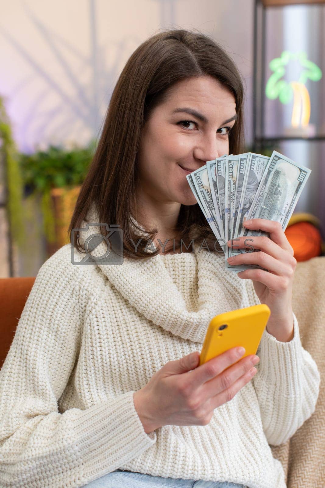Smiling happy young woman counting money cash use smartphone income saves lottery win budget at home by efuror Vectors & Illustrations with Unlimited Downloads - Yayimages